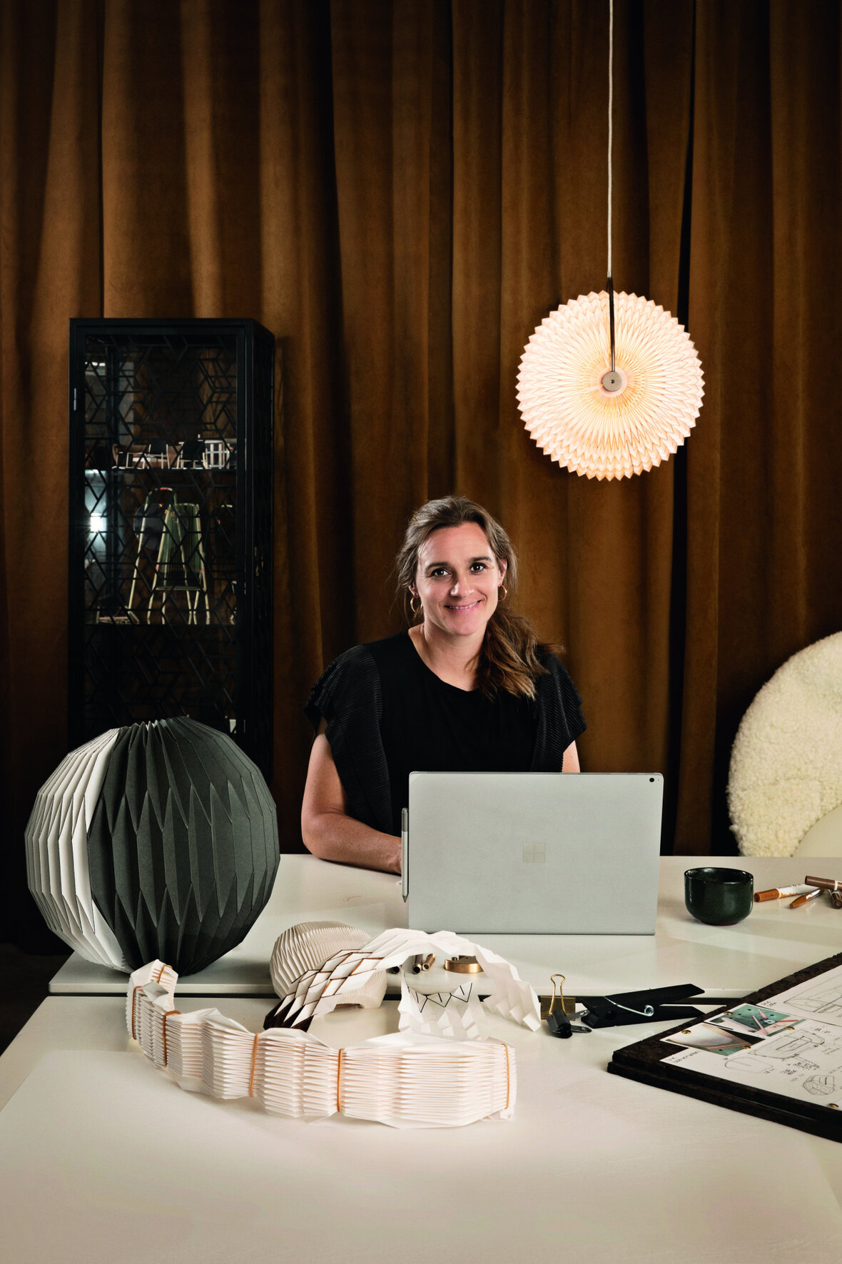 Rikke Frost ved sit skrivebord, hvor lampen Caleo ligger