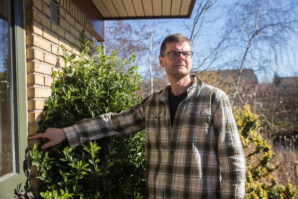 Rådgiver peger på vindue udenfor et hus.