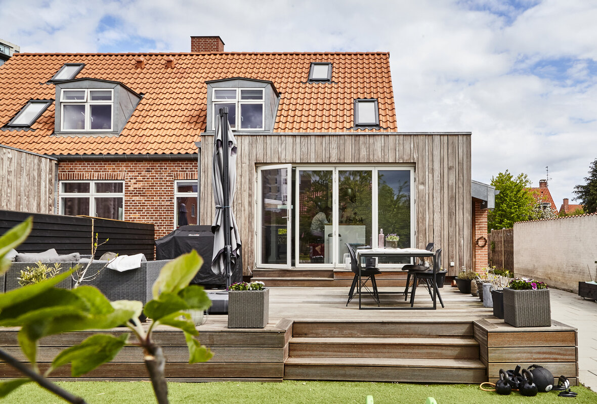 Hus med tilbygning og træterrasse
