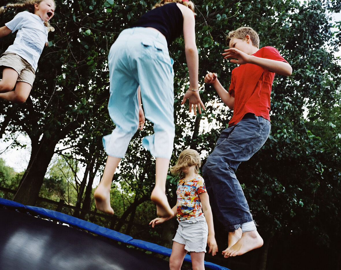 børn hopper på trampolin i haven